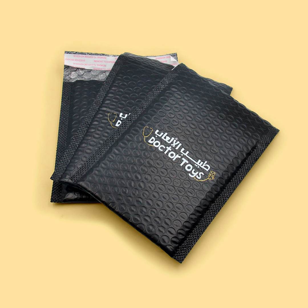 Black bubble-lined poly mailers with a printed brand mark and the bubble texture visible