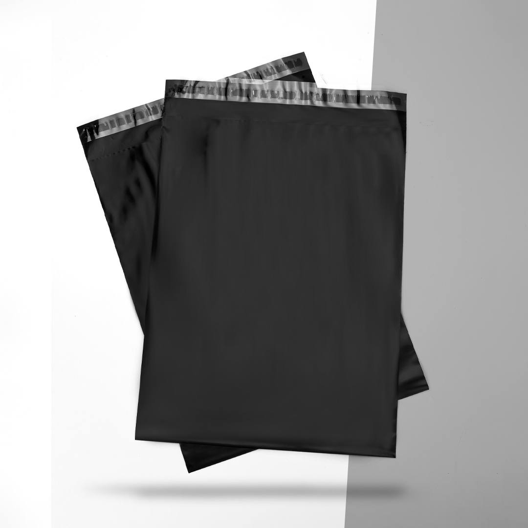 Two black poly mailers overlapping on a split grey and white background
