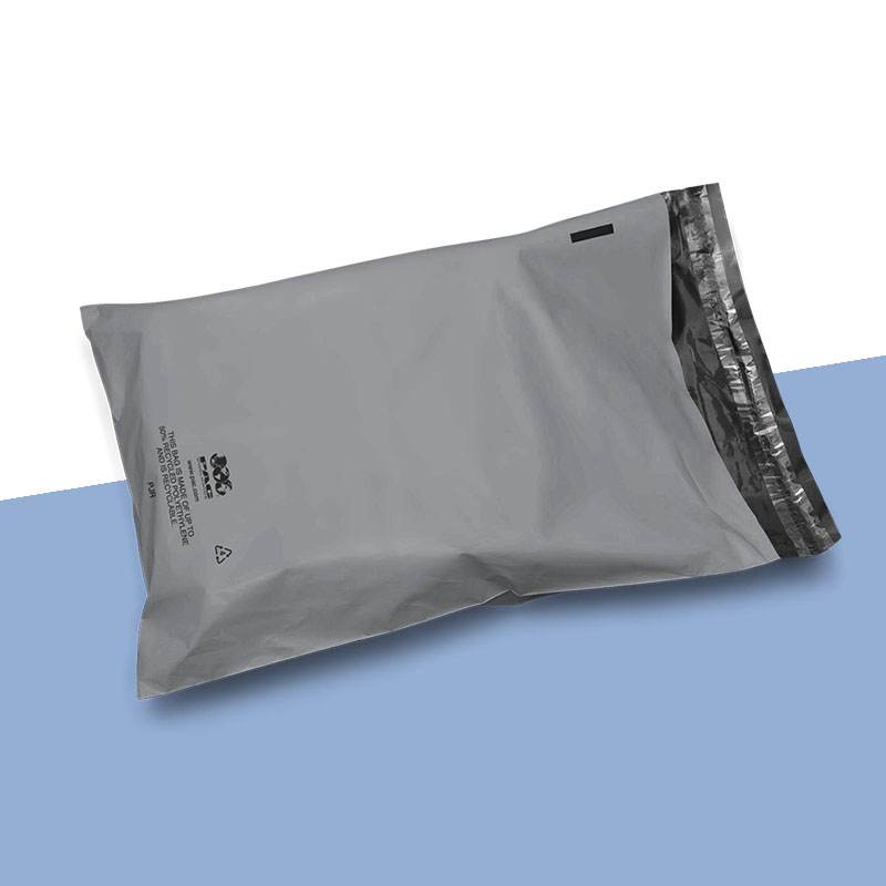 Grey mailer packed and sealed, printed along one edge with a recycled-content message