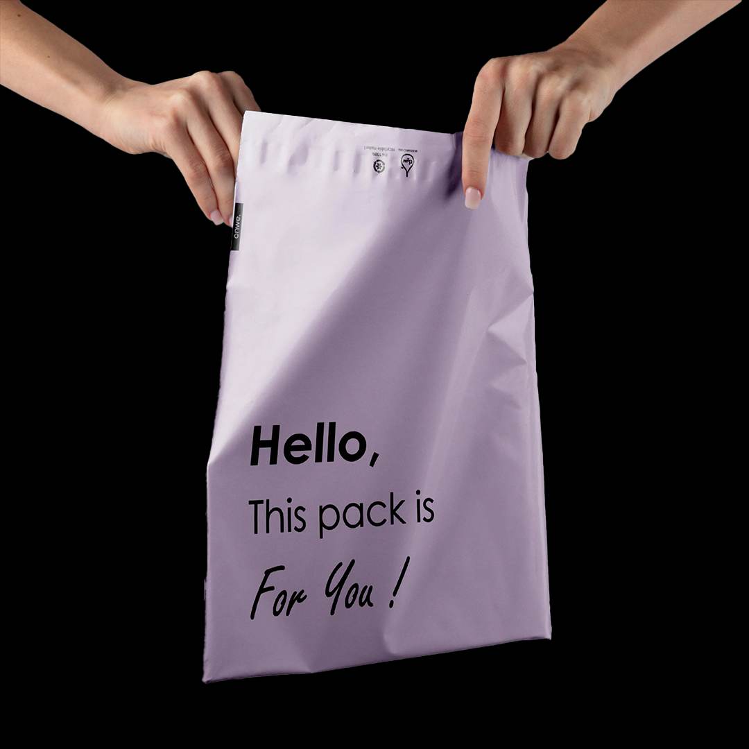 Two hands holding a packed lilac garment mailer printed with a short message