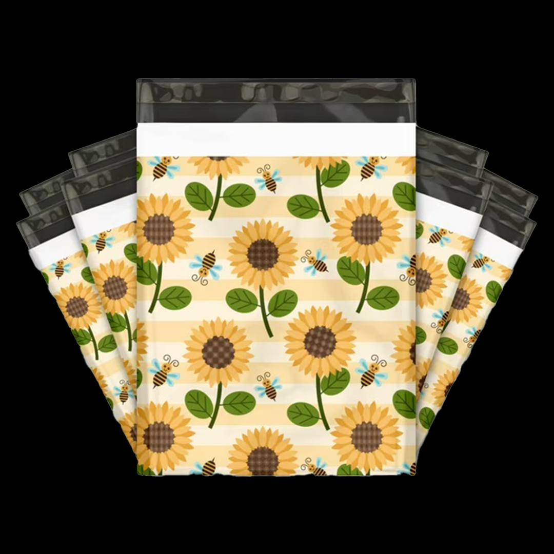 Mailers fanned out showing a sunflower and bee pattern on a soft striped background