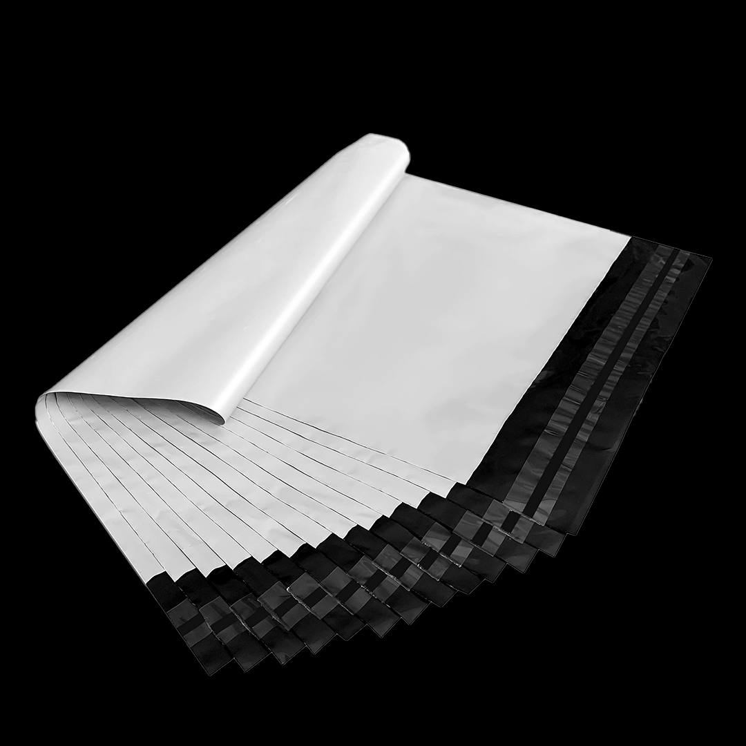 Rolled bundle of plain white poly mailers ready for a packing bench