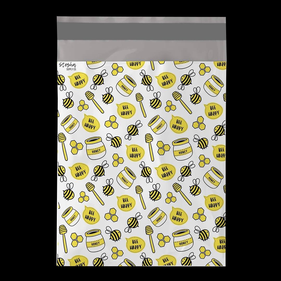 White mailer covered in a printed pattern of bees, honey jars and honeycomb shapes