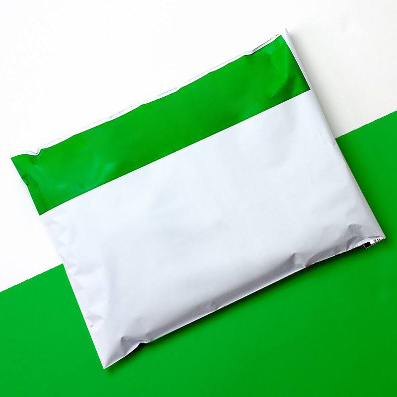White poly mailer with a green flap section, lying flat and sealed